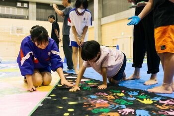 「キッズゲルニカ」作品を中学生、アメリカの高校生、市民が一緒に制作！3.5m×7.8mの巨大アートが完成　キャンバスに、みんなで平和への願いを。